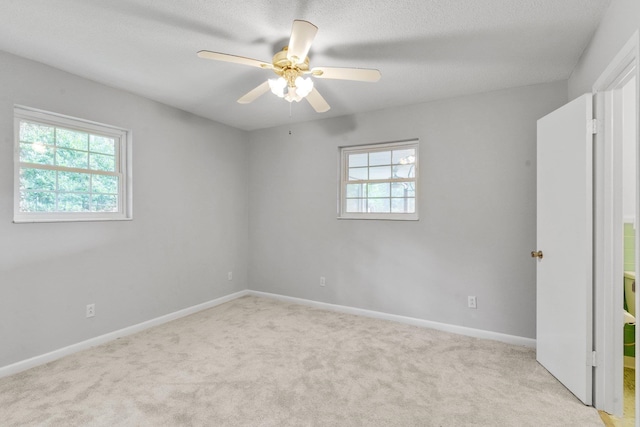 carpeted spare room with a textured ceiling and ceiling fan