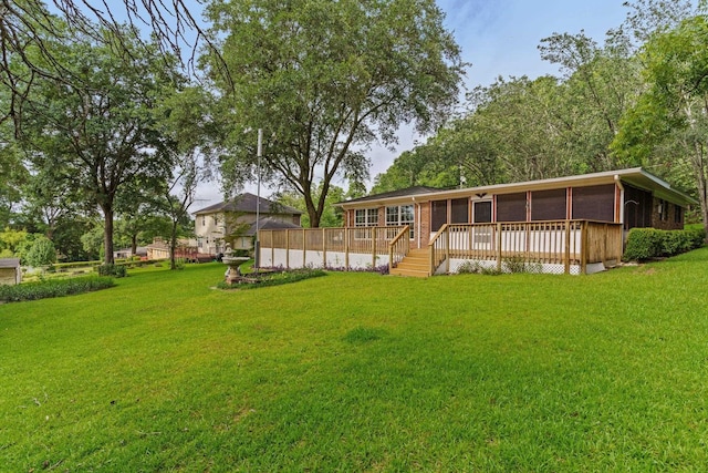 rear view of house featuring a deck and a yard