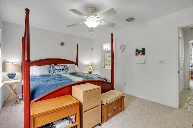 bedroom featuring light colored carpet, visible vents, a ceiling fan, ensuite bath, and baseboards