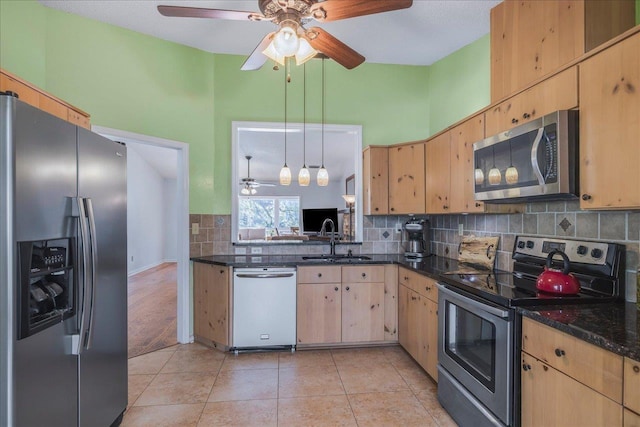 kitchen featuring decorative light fixtures, light tile patterned floors, stainless steel appliances, tasteful backsplash, and a sink