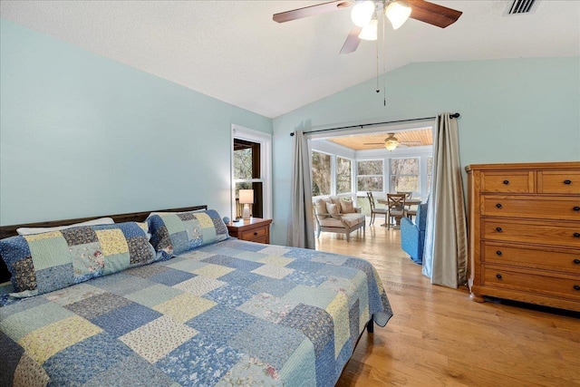 bedroom with light wood finished floors, ceiling fan, visible vents, and vaulted ceiling