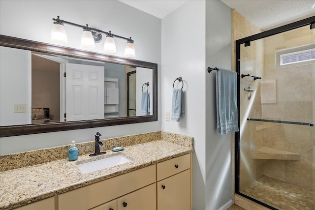 bathroom featuring a stall shower, vanity, and a textured ceiling