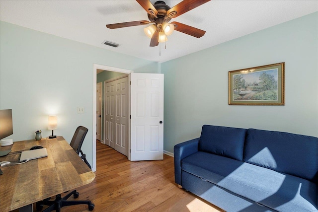 home office with visible vents, ceiling fan, light wood-style flooring, and baseboards