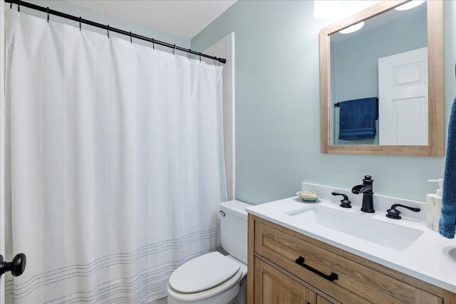 bathroom featuring toilet, a textured ceiling, and vanity