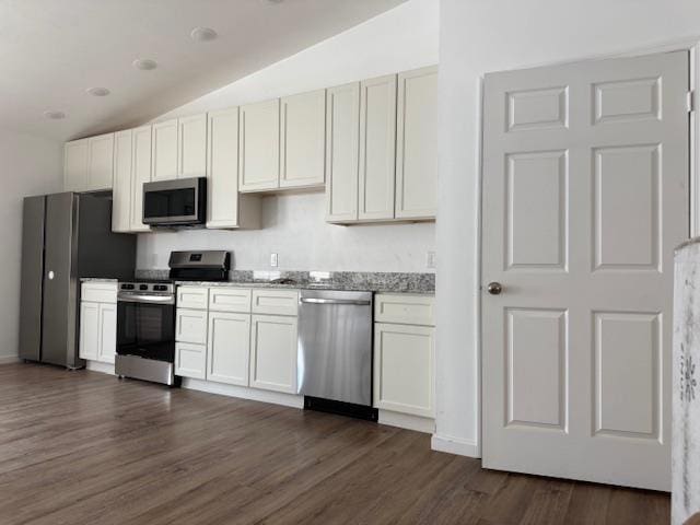 2754 Roberts Ave, Tallahassee, FL 32310 - kitchen featuring dark wood-style floors, stainless steel appliances, vaulted ceiling, light stone countertops, and white cabinetry