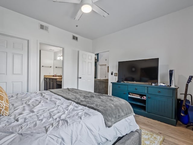 bedroom with ensuite bath, ceiling fan, and light hardwood / wood-style flooring