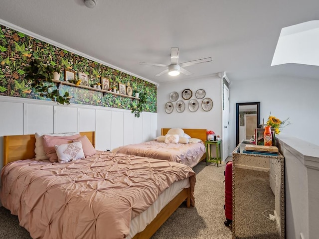 carpeted bedroom with a skylight, ceiling fan, and crown molding