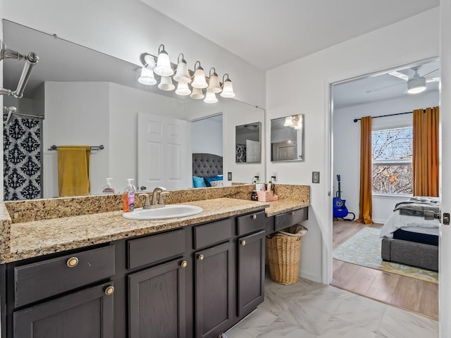 bathroom with hardwood / wood-style floors, ceiling fan, and vanity