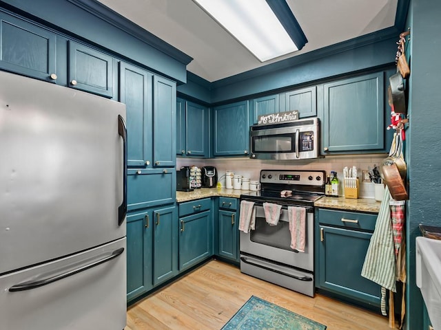 kitchen with blue cabinetry, light stone countertops, tasteful backsplash, appliances with stainless steel finishes, and light wood-type flooring