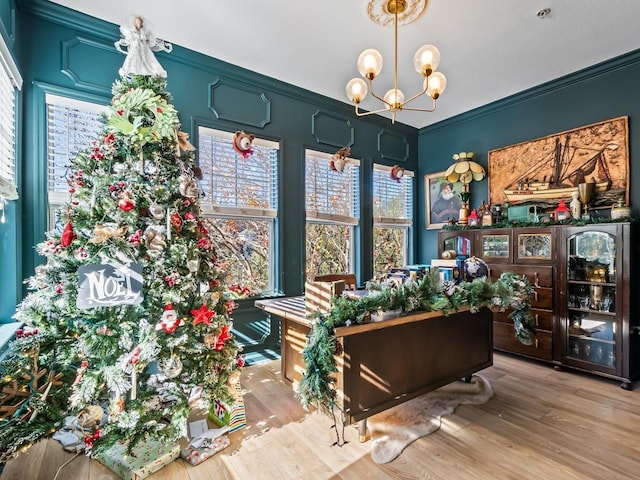 interior space featuring a notable chandelier, light wood-type flooring, and crown molding