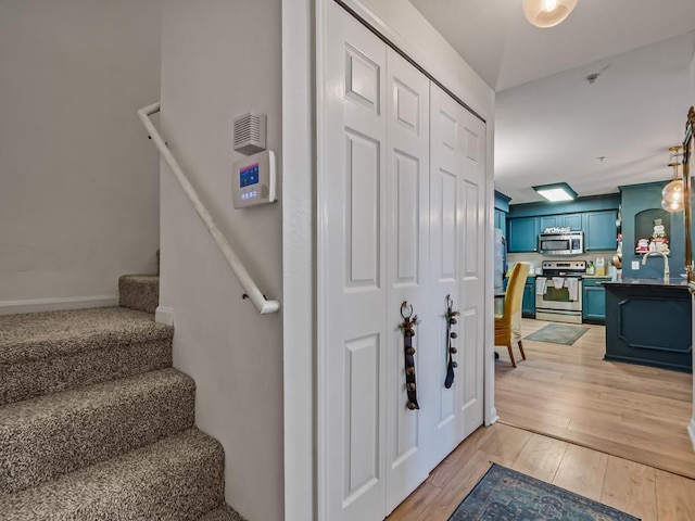 stairway with wood-type flooring and sink