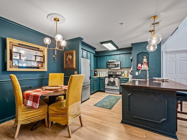 dining area with a chandelier, sink, and light hardwood / wood-style floors