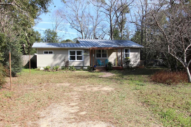 single story home featuring fence, a front lawn, and metal roof