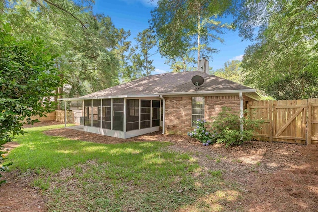 3585 Gardenview Way, Tallahassee, FL 32309 - back of property featuring a sunroom, a fenced backyard, a shingled roof, and a gate