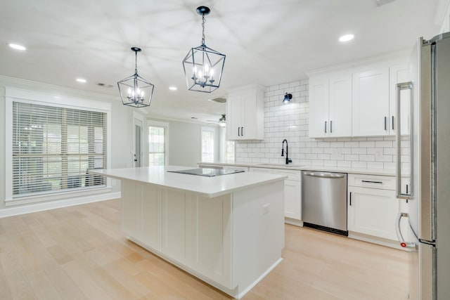3585 Gardenview Way, Tallahassee, FL 32309 - kitchen featuring stainless steel appliances, a chandelier, tasteful backsplash, crown molding, and a center island