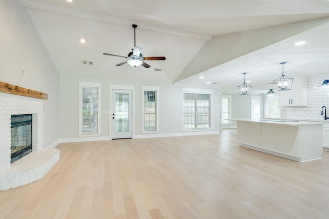 3585 Gardenview Way, Tallahassee, FL 32309 - unfurnished living room with a ceiling fan, a fireplace, beam ceiling, a chandelier, and light wood finished floors