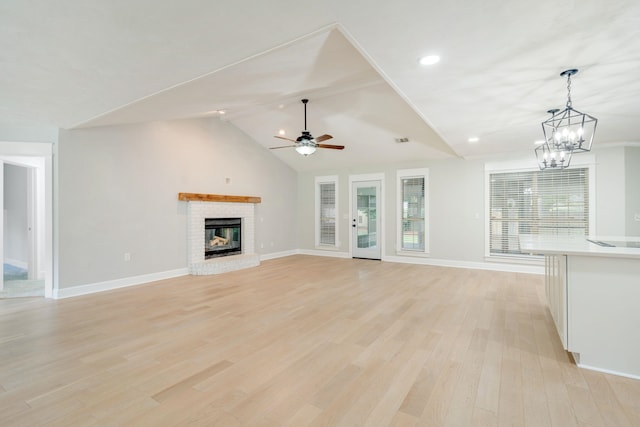 3585 Gardenview Way, Tallahassee, FL 32309 - unfurnished living room featuring a ceiling fan, light wood-style floors, a fireplace, a chandelier, and lofted ceiling