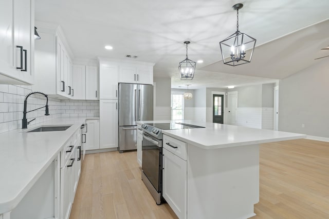 3585 Gardenview Way, Tallahassee, FL 32309 - kitchen featuring appliances with stainless steel finishes, a center island, recessed lighting, a wainscoted wall, and white cabinetry