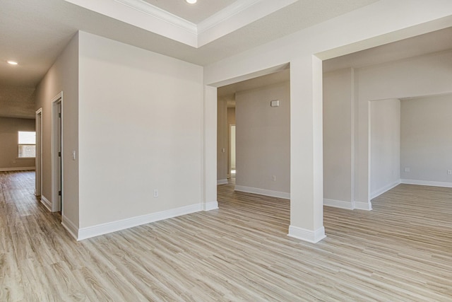 empty room with ornamental molding and light hardwood / wood-style flooring