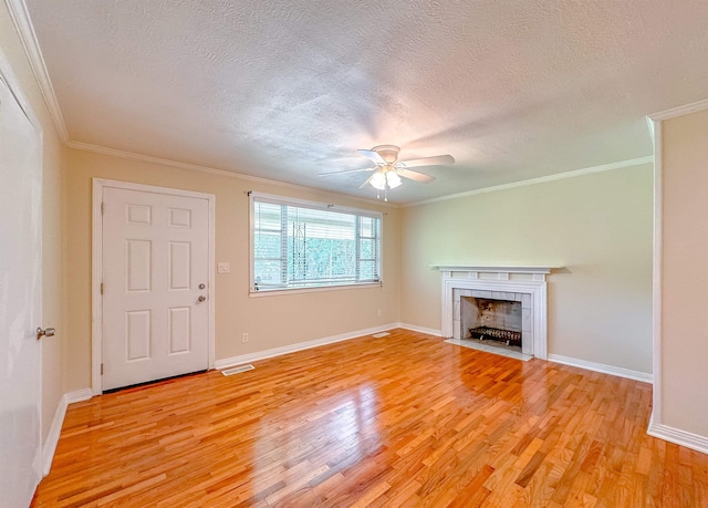 1514 Sharon Rd, Tallahassee, FL 32303 - unfurnished living room with light wood-style floors, a textured ceiling, crown molding, a ceiling fan, and a fireplace