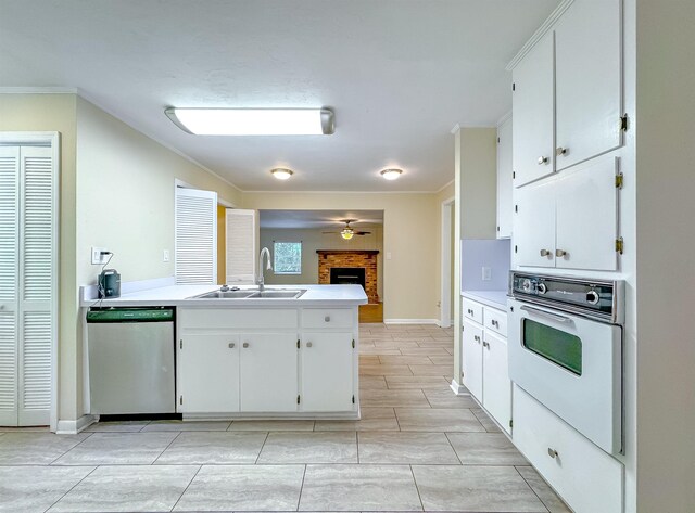 1514 Sharon Rd, Tallahassee, FL 32303 - kitchen featuring stainless steel dishwasher, white oven, a peninsula, white cabinets, and ornamental molding