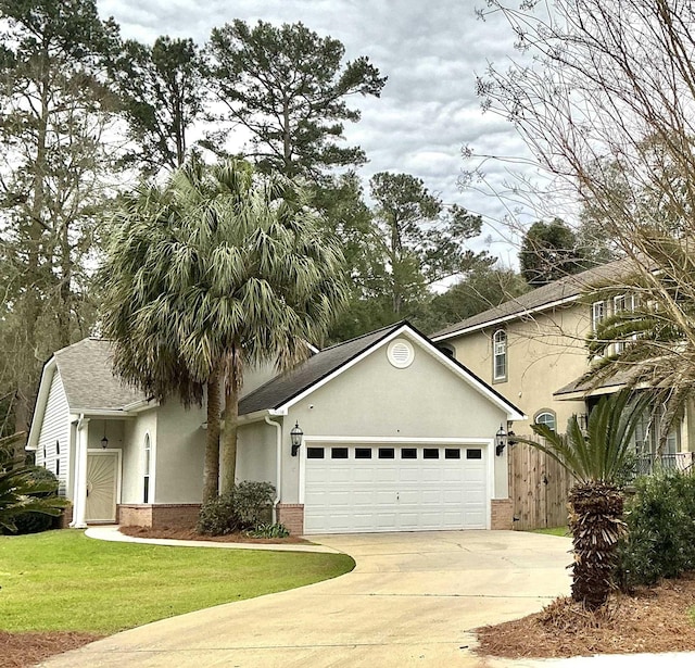 view of front facade with an attached garage, brick siding, driveway, stucco siding, and a front lawn