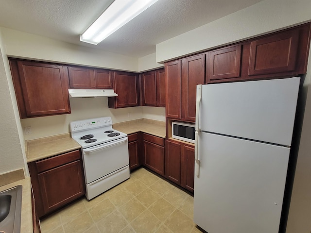 kitchen featuring a textured ceiling, white appliances, and sink