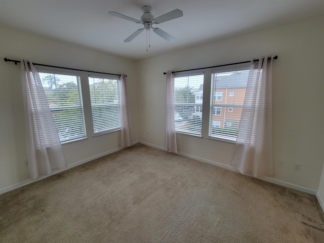 carpeted empty room featuring ceiling fan