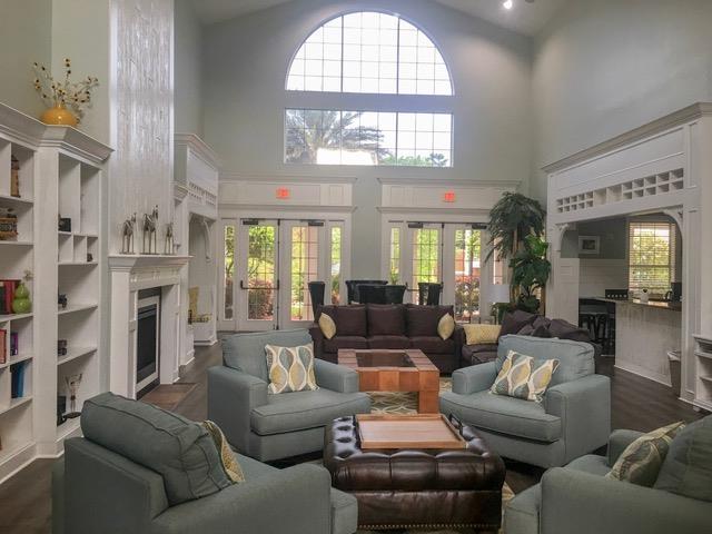 living room with plenty of natural light, built in features, french doors, and a high ceiling