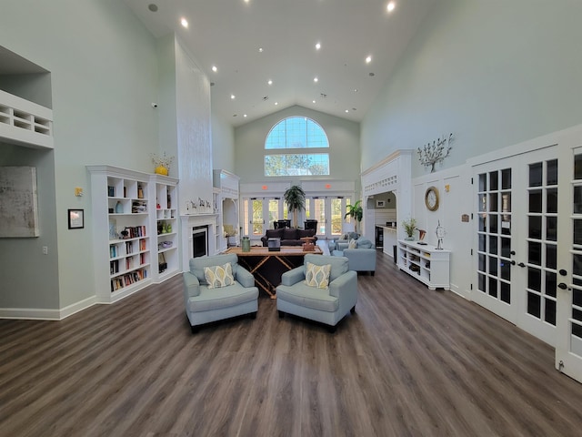 living room featuring dark hardwood / wood-style floors, a towering ceiling, and french doors