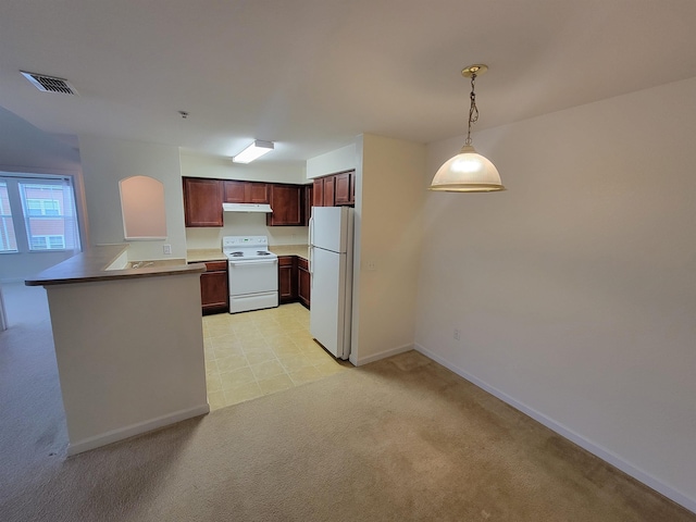 kitchen featuring kitchen peninsula, pendant lighting, white appliances, and light colored carpet