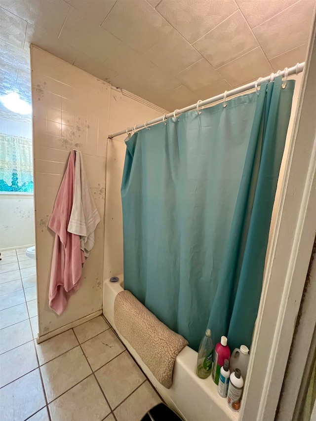 bathroom with shower / bath combo and tile patterned floors