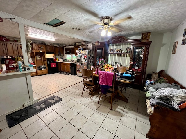 dining area with a textured ceiling, light tile patterned floors, and ceiling fan