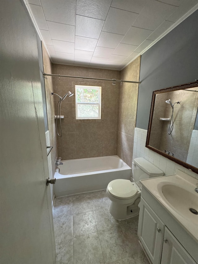 full bathroom featuring crown molding, vanity, tiled shower / bath combo, and toilet