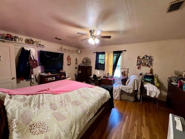 bedroom with ceiling fan, a textured ceiling, and wood-type flooring