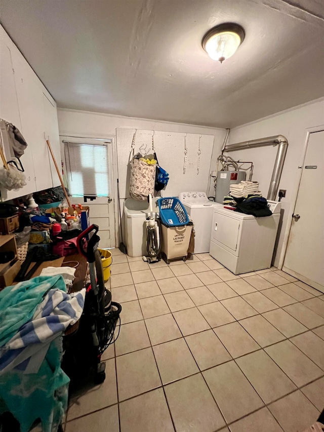 laundry area featuring water heater, washing machine and dryer, and light tile patterned floors