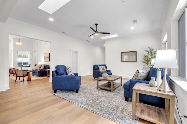 living room with crown molding, a skylight, ceiling fan, and light wood-type flooring