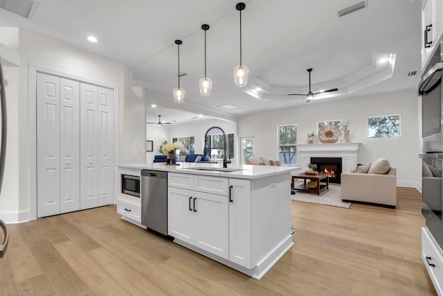 kitchen featuring appliances with stainless steel finishes, pendant lighting, white cabinetry, sink, and ceiling fan