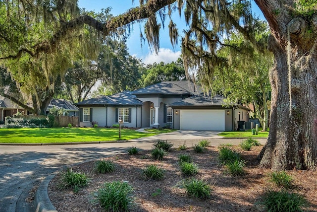 single story home with a garage and a front lawn