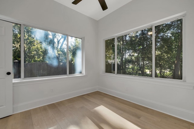 empty room featuring light hardwood / wood-style flooring, ceiling fan, and vaulted ceiling