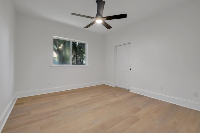 empty room with ceiling fan and light hardwood / wood-style flooring