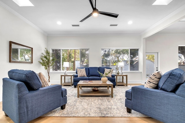 living room with plenty of natural light, light hardwood / wood-style floors, and a skylight