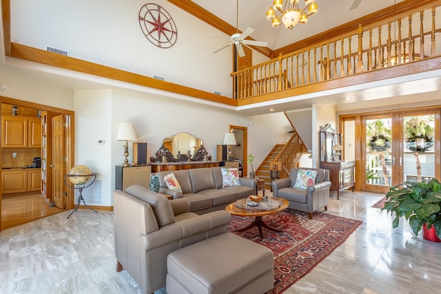 living room featuring ceiling fan with notable chandelier, a towering ceiling, and french doors