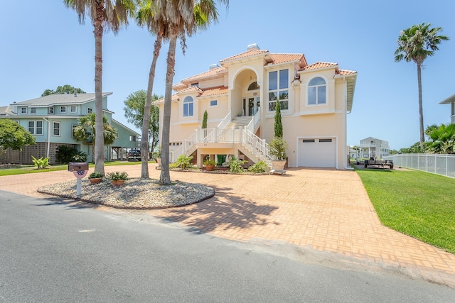 mediterranean / spanish-style house with a porch, a garage, and a front lawn