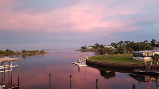 dock area featuring a lawn and a water view