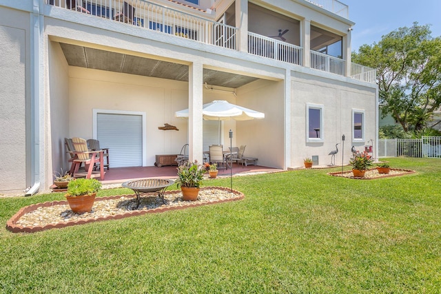 back of house with a lawn and a patio