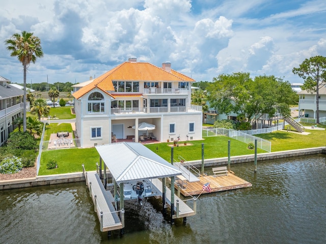 dock area with a patio area, a balcony, a yard, and a water view