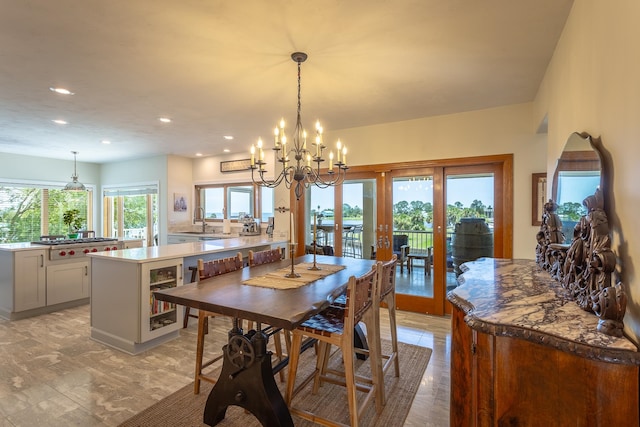 dining room featuring french doors, beverage cooler, a notable chandelier, and sink