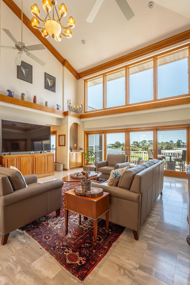 living room featuring ceiling fan with notable chandelier, crown molding, and high vaulted ceiling