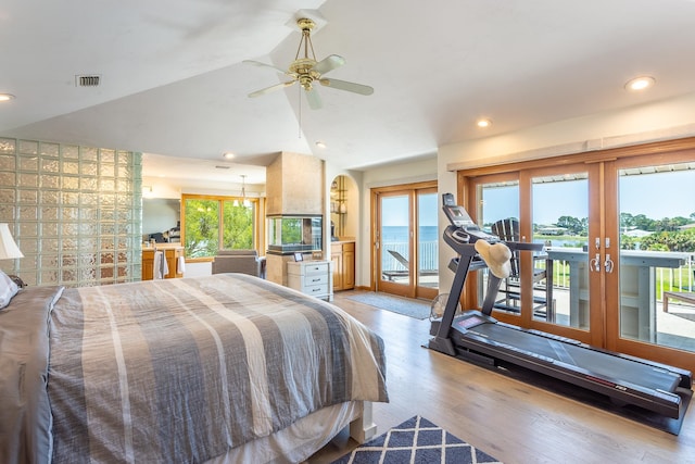 bedroom featuring access to exterior, french doors, lofted ceiling, ceiling fan with notable chandelier, and light wood-type flooring